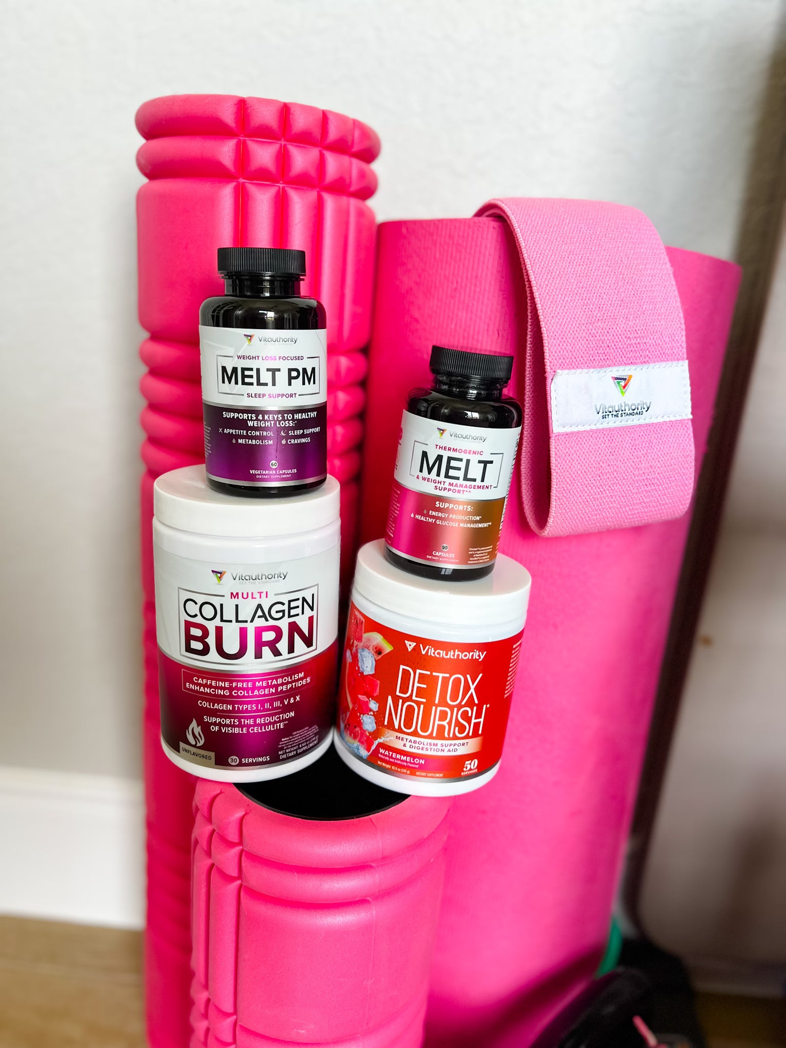 Vitatuhority supplement bottles on a pink foam roller